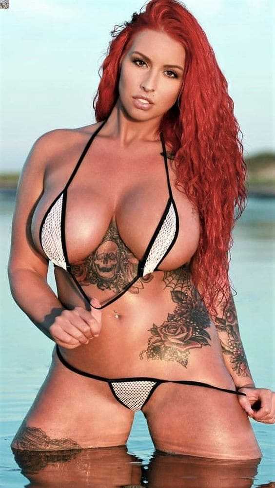 Sexy redhead girl with big tits in a bikini.